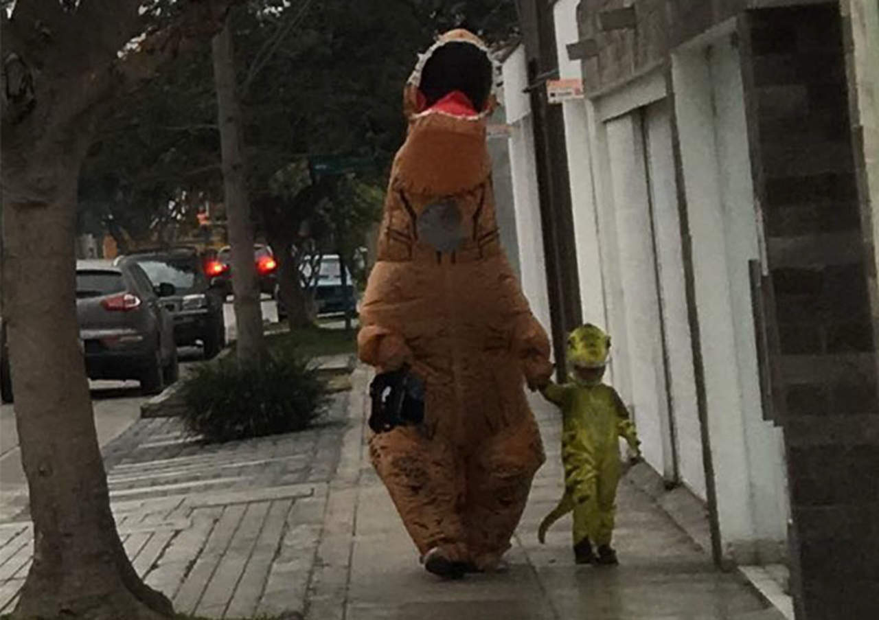 Papá lleva a la escuela a su pequeño con disfraz de dinosaurio. Noticias en tiempo real