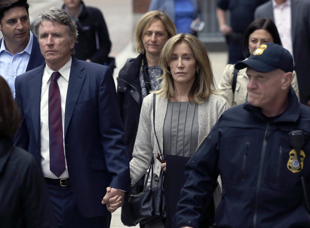 Va a declarar. Felicity Huffman, centro, sale de una corte federal con su hermano Moore Huffman Jr. (AP)