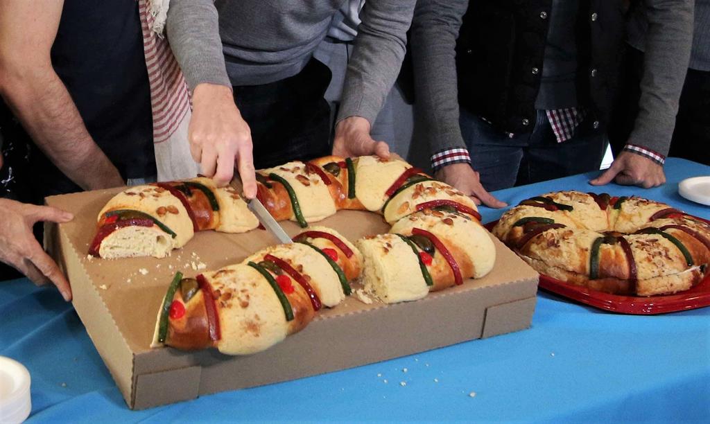 personas cortando la rosca de reyes