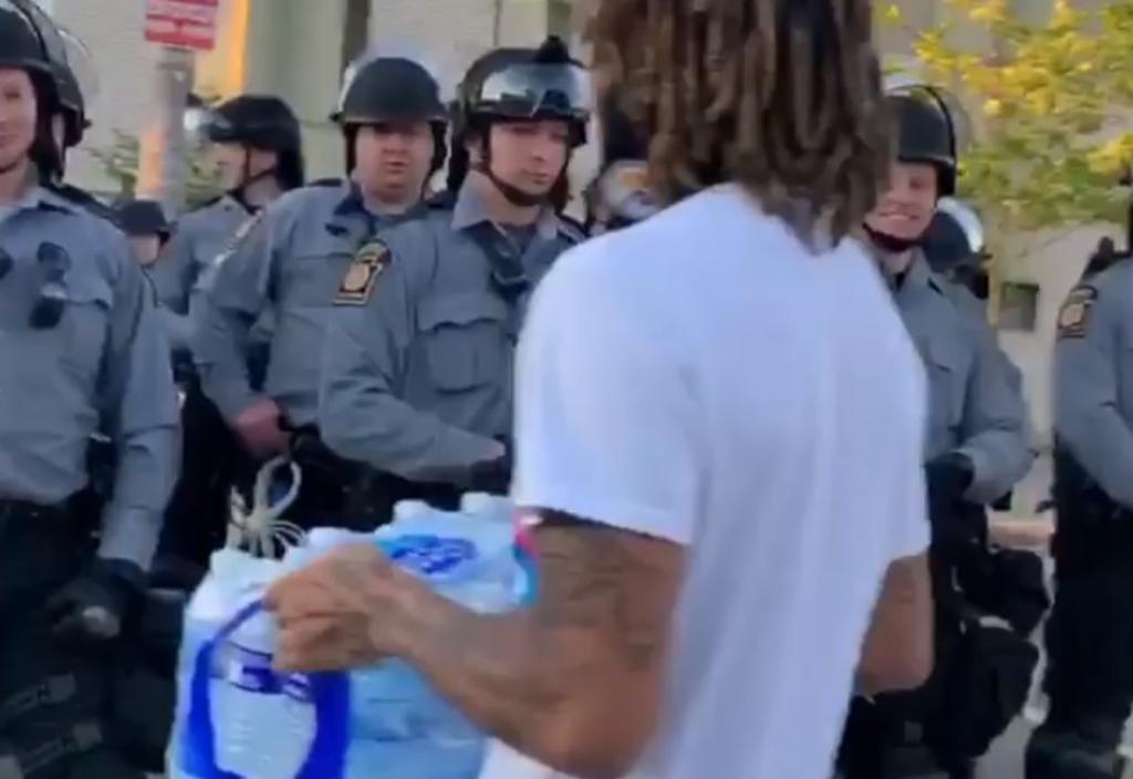 VIDEO: Joven reparte agua a policías durante manifestaciones en EUA. Noticias en tiempo real